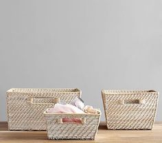 two wicker baskets sitting on top of a wooden table