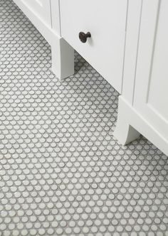 a bathroom with a white vanity and tile flooring that looks like hexagonal tiles