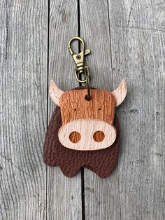 a cow keychain hanging on a wooden fence