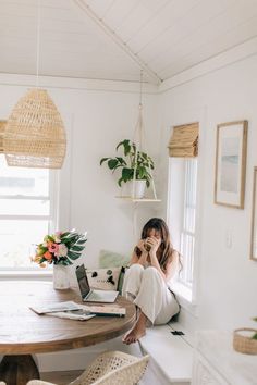 a woman sitting at a table talking on her cell phone