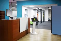 an empty gym with blue walls and wooden flooring is seen in this image from the front entrance