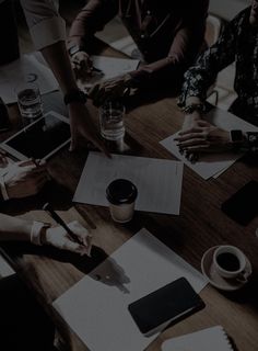 people sitting at a table with papers and pens