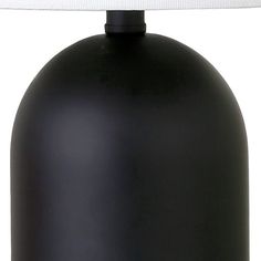 a black lamp with a white shade on it