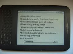 an electronic device with several languages displayed on it's display screen, sitting on a white surface