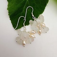 DESCRIPTION| These sea glass and fresh water pearl cluster earrings are perfect for a touch of elegance. Combining clear sea glass with white freshwater pearls for a tastefully feminine accessory that's fun to wear! While each pair is made to order and will have slight variations, the ones you receive will very closely resemble the ones pictured.  DETAILS| Approximately 1.5" total length All findings are sterling silver  All wire earrings come with rubber stoppers to keep them in place Your purc Elegant Silver Sea Glass Earrings, Elegant Sea Glass Dangle Earrings, Clear Sea, Pearl Cluster Earrings, Lover Jewelry, Glass Creations, White Sea Glass, Jewelry Beach, White Sea