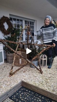 a woman standing in front of a wooden star