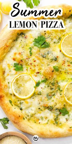 a pizza with lemons and parsley on it, next to some other ingredients