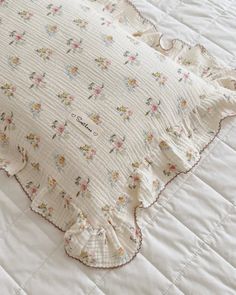 a white quilted bedspread with flowers on it