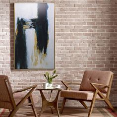 two chairs and a table in front of a brick wall with a painting on it