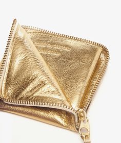 a gold purse with zippers on it