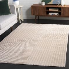 a living room with a white couch and rug on the floor next to a coffee table