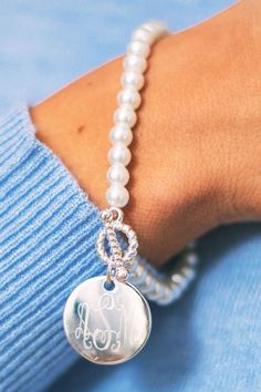 Looking for a sweet and classic bracelet to give a special woman in your life? This Monogrammed Pearl Bracelet with a 7/8 inch charm and faux pearl beads is the perfect piece to make her feel special. Personalize it with her initials in the font of your choice. This bracelet has a stretchy fit so that it can fit almost any wrist. Elegant White Monogram Jewelry, Elegant Monogram Name Bracelet As Personalized Gift, Elegant Monogram Name Bracelet For Personalized Gift, Elegant Monogrammed Name Bracelet For Personalized Gift, Adjustable White Monogram Jewelry, Silver Jewelry With Pearl Charm Initial Pendant, Silver Initial Pendant Jewelry With Pearl Charm, Personalized Monogram Adjustable Jewelry, Personalized Adjustable Monogram Jewelry