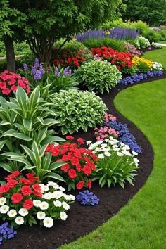 a flower garden with many different colored flowers in the center and green grass around it