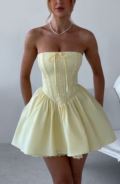 Fall in love with the Evie dress, a flirty mini with a super full skirt made with tulle for extra volume. This strapless style has a boned bodice for an extra snatched look, complete with ribbon to the bust and lace up back. Dress her up with effortless waves, pointed heels and metallic jewellery.



Colour: Lemon.

Non-stretch cotton blend fabric.

Fully lined.

Full skirt with tulle and gathered detail at waist.

Boned bodice with v-shape hem.

Strapless.

Ribbon tie at bust.

Lace trim detail 21 Birthday Outfit Ideas, Short Birthday Dress, 21st Birthday Dress, Homecoming Dresses Satin, Vestidos Color Vino, Strapless Homecoming Dresses, Lace Up Back Dress, Dinner Dresses, Dresses Satin