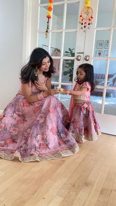 ✨ When the mother and daughter pair up, the lehenga sets are perfect for twinning.  ✨ The Floral Print Lehenga is a beautiful piece that will make a statement for your little girl. The lehenga has an attached dupatta and is accented with a gold border. This set includes a beautiful floral lehenga and matching bolero with matching floral motifs. The lehenga features a full-length, pleated skirt and floral embroidery on the bodice.  ✨ Our Twinning Set is perfect for a girl's special day. Designed with a pleated skirt, the lehenga is accented with beautiful flowers, perfect for any little girl's celebration. This is what organza lehenga stands for and, as the color itself is sufficient to create a style statement, it is perfect for eids, receptions,  engagements, or weddings of your near and Mother Daughter Lehenga Choli, Mom Daughter Matching Lehenga, Mom Daughter Matching Dresses Mommy And Me, Mother Daughter Fashion Indian, Mom Daughter Matching Dresses Indian, Mom And Daughter Dresses Indian, Mother Daughter Twinning Dresses, Family Matching Outfits Indian, Lehenga Sequins