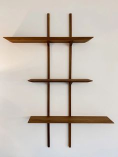 three wooden shelves on the wall, one with four intersecting sections and one without two