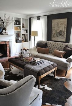 a living room filled with furniture and a fire place under a painting on the wall