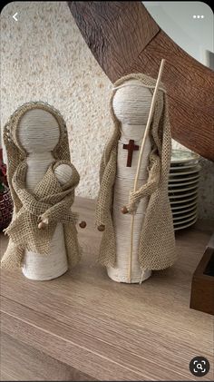 two burlap cloth dolls are standing next to each other on a wooden table