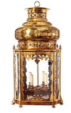 an antique brass lantern with three candles in it's center and the light on top