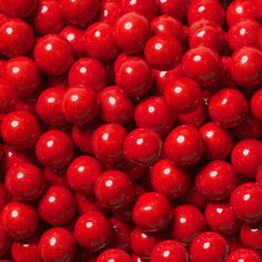 close up view of red candy balls in the shape of an apple, background or wallpaper