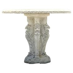 a white marble table with an ornate design on the top and base, against a white background