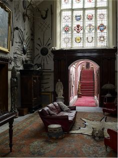 a living room filled with furniture and a red carpet