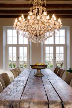 a large wooden table sitting in front of a chandelier