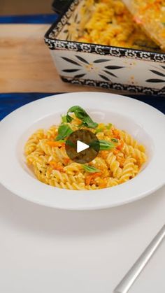 a white plate topped with pasta next to a casserole dish