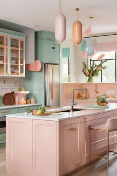 a kitchen with pink cabinets and gold accents