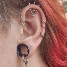 a woman with red hair wearing ear piercings