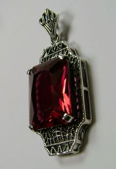 "Simulated Red Ruby Pendant Lantern Design#P13 Custom Made About 6 months ago I found a lovely Art Deco brooch and fell in love with the design. Fashioned in the design of the brooch, I now offer this lovely Antique reproduction pendant in sterling silver (matching 18ct earrings also available for sale). The flawless Simulated 9ct red/pink ruby is 15mm long (just over 9/16\") and 12mm in width (1/2th\"). The pendant is 1 3/8th inches long, it is 9/16th\" wide. The bail opening is 3.5mm wide and Classic Red Birthstone Jewelry, Antique Ruby Necklace For Formal Occasions, Classic Evening Ruby Jewelry, Classic Red Hallmarked Necklace, Classic Red Gemstone Jewelry, Classic Red Pendant Necklace, Red Antique Engraved Necklace, Red Hallmarked Evening Jewelry, Vintage Ruby Necklace For Formal Occasions