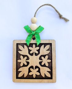 a wooden ornament with a green bow on it