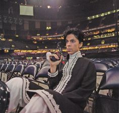 a man sitting in a stadium holding a camera