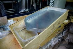 a wooden box filled with lots of tools on top of a table next to a knife holder