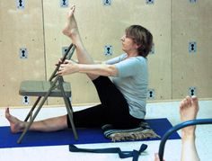 a woman is sitting on the floor with her legs up and one foot in the air