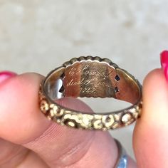 a person holding a ring with writing on it