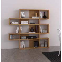 a book shelf with many books on it and a chair in the corner next to it