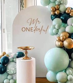 a table topped with balloons and a white bottle next to a sign that says, my one - step