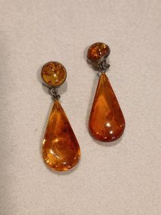 Vintage amber on silver earrings. Made in Germany in the 1950s to 1970s. These earrings comprise an amber  teardrop hanging from a round piece of amber set in silver. The proportions are very pleasing. Amber jewellery was often sold as souvenirs 50 years ago: I bought some myself at this time. The earrings have a soft clip, and are comfortable to wear. The earrings are 5.5 cm long (drop 3.8 cm). They are in perfect condition. Vintage Teardrop Clip-on Earrings As Gift, Vintage Amber Dangle Earrings, Vintage Amber Drop Earrings, Vintage Amber Nickel-free Earrings, Vintage Formal Drop Earrings, Formal Vintage Drop Earrings, Vintage Orange Dangle Earrings, Vintage Nickel-free Teardrop Clip-on Earrings, Vintage Baltic Amber Jewelry For Formal Occasions