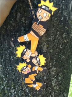 a tree with some cartoon characters hanging from it's bark and on the trunk