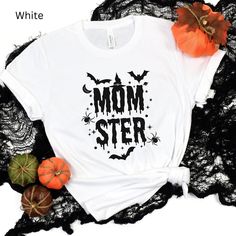 Momster Shirt, Mom Halloween Shirt, Halloween Party Shirt for Moms, Mama Halloween Tees, Momster Tee, Momster T-Shirt This classic unisex jersey short sleeve tee fits like a well-loved favorite. Soft cotton and quality print make users fall in love with it over and over again. These t-shirts have-ribbed knit collars to bolster shaping. The shoulders have taping for better fit over time. Dual side seams hold the garment's shape for longer.  .: 100% Airlume combed and ringspun cotton (fiber content may vary for different colors) .: Light fabric (4.2 oz/yd² (142 g/m .: Retail fit .: Tear away label .: Runs true to size Black T-shirt With Letter Print For Costume Party, Halloween Novelty Tops With Funny Text, Halloween Fun T-shirt With Funny Text, Funny Halloween T-shirt With Letter Print, Short Sleeve Top With Letter Print For Costume Party, Halloween Crew Neck Top With Funny Text, Halloween Novelty Shirt With Letter Print, Novelty Halloween Shirt With Letter Print, Funny Halloween Shirt With Letter Print