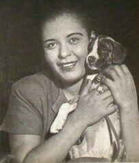 a black and white photo of a woman holding a dog