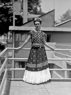 an old black and white photo of a woman standing on a balcony with her arms outstretched