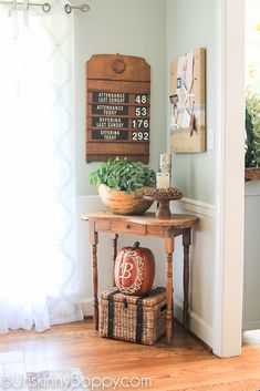 a wooden table sitting in the corner of a room next to a potted plant