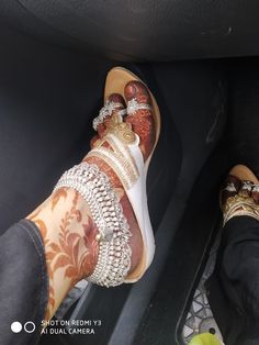 two people wearing shoes with chains on their feet in the back seat of a car