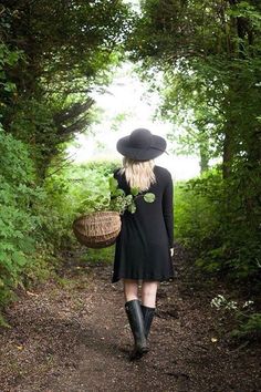 a woman walking down a path in the woods