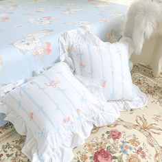 a bed with blue and white comforters on top of it next to a stuffed animal