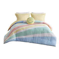 a bed with colorful comforters and pillows