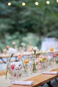 a long table with vases and flowers on it