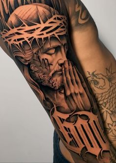 a man with tattoos on his arm and shoulder holding hands to his face while wearing a crown